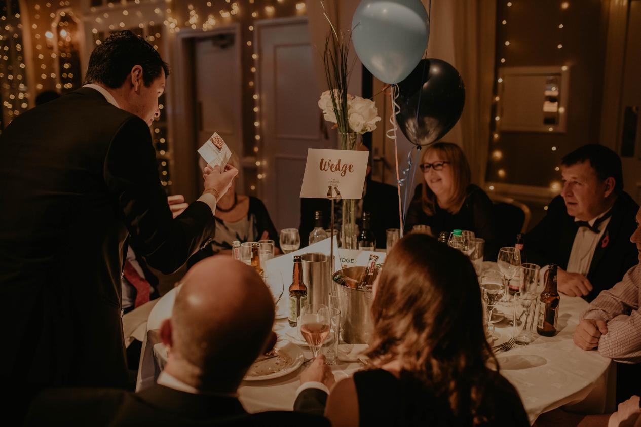 close up magician performing at a table for a Christmas party