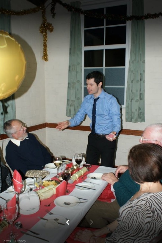 close up magician performing table to table magic at a christmas party