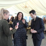close hand magician performing to two women at a party