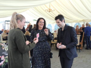 close hand magician performing to two women at a party