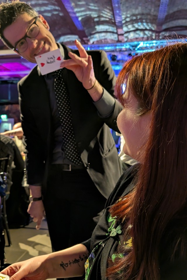 magician revealing a playing card at a formal party
