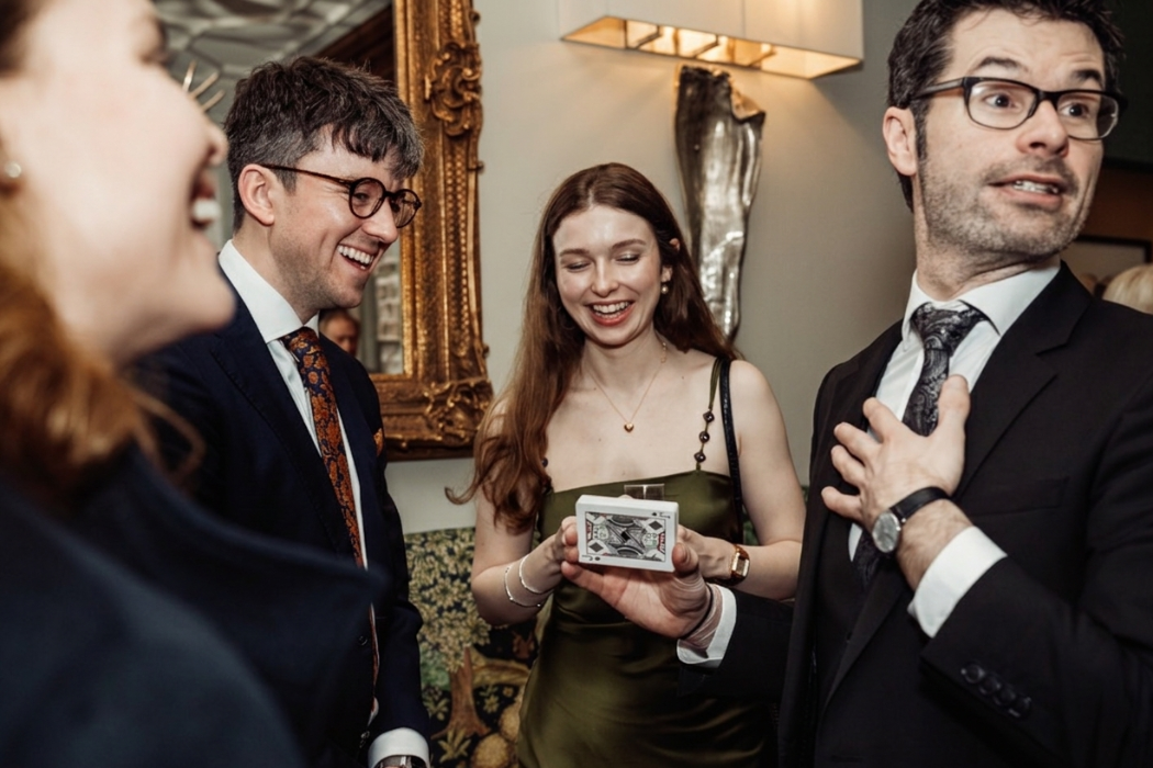 guests laughing naturally at ed's close up magic and comedy at an exclusive london party