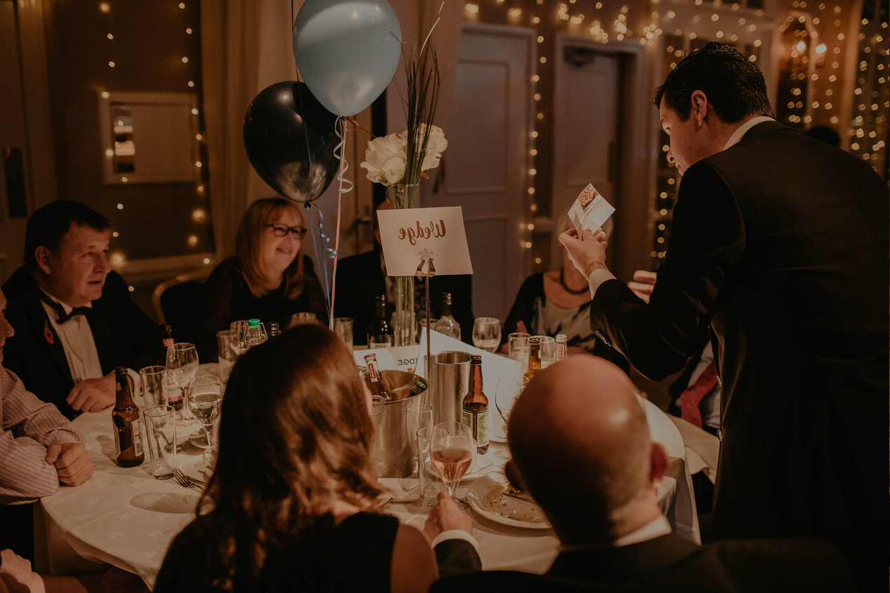 a close up magician performing magic to a table at a corporate event in sheffield