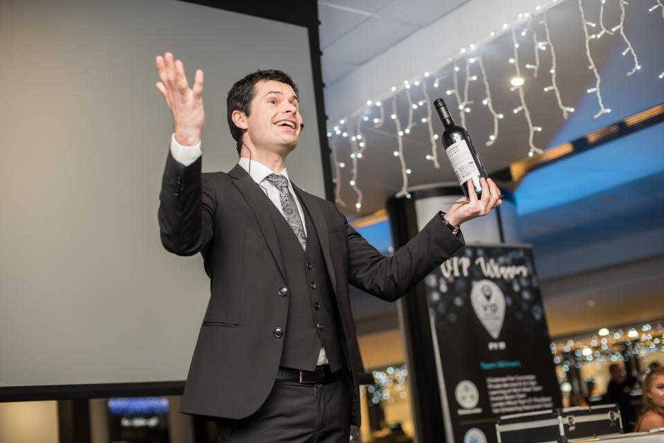 professional stage magician making a bottle of wine appear