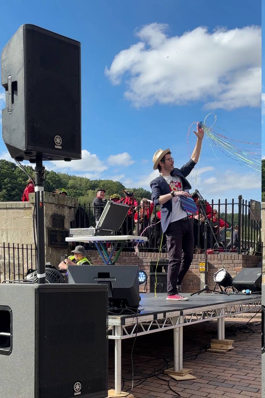 festival magician performing on stage at an outdoor street festival