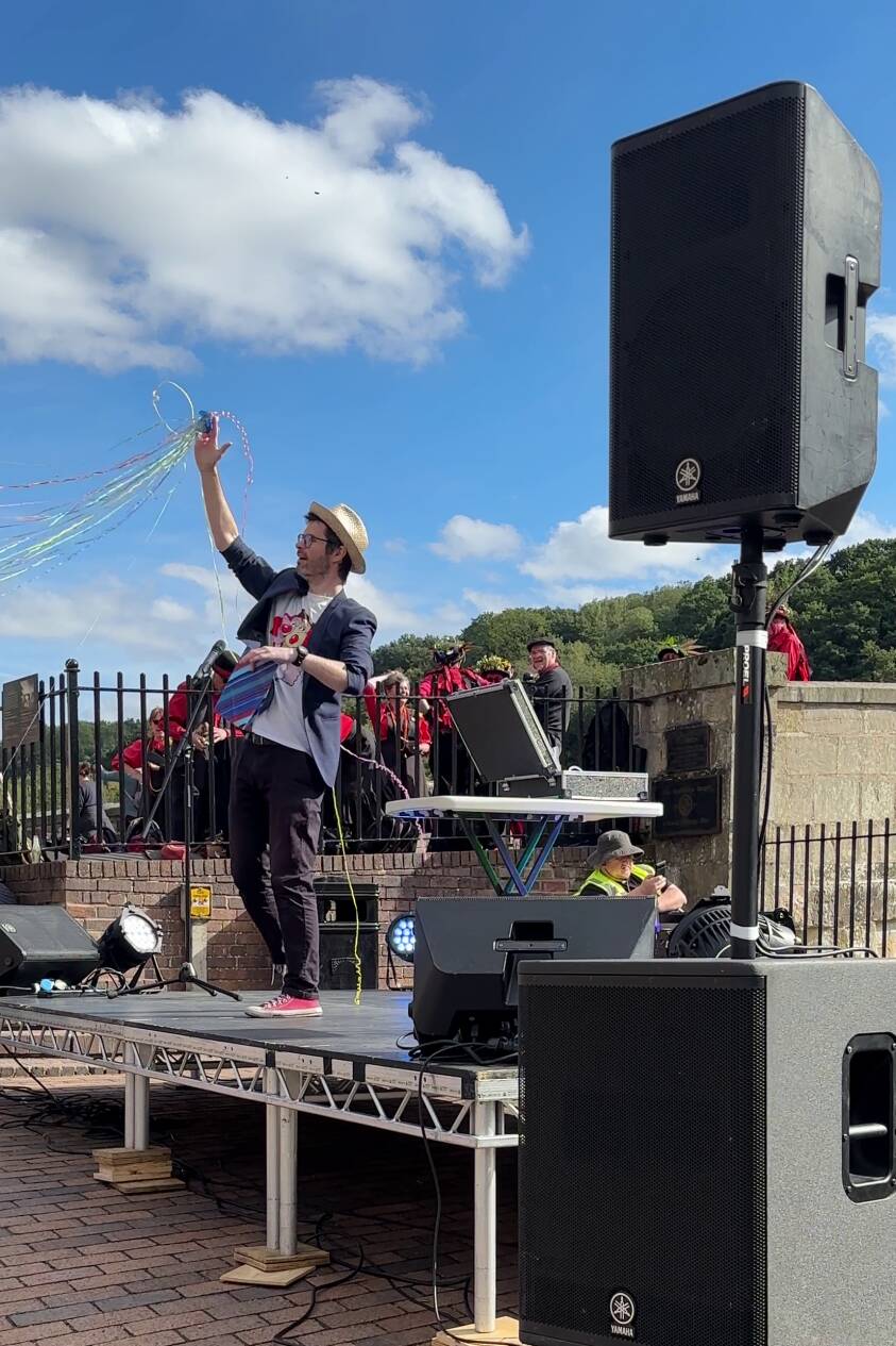 magician ed performing a show on an outdoor stage at a summer festival
