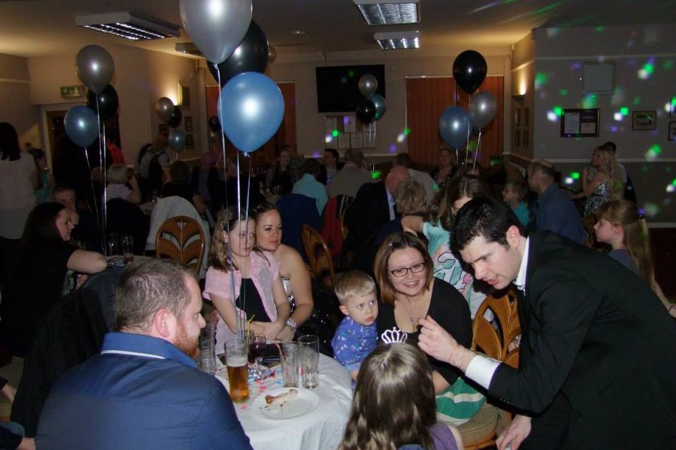 close up magician performing magic to a mixed group at a party in south yorkshire